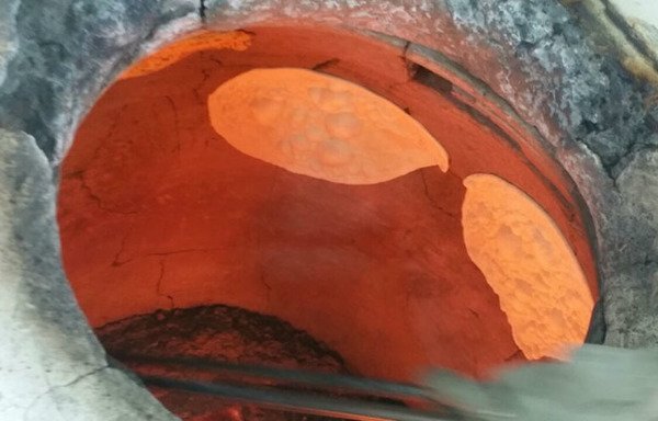 نان معروف تنوری عراق در یک اجاق سفالی در یک نانوایی در خیابان مصارف دریکی از شلوغترین منطقه های فلوجه پخته می شود.