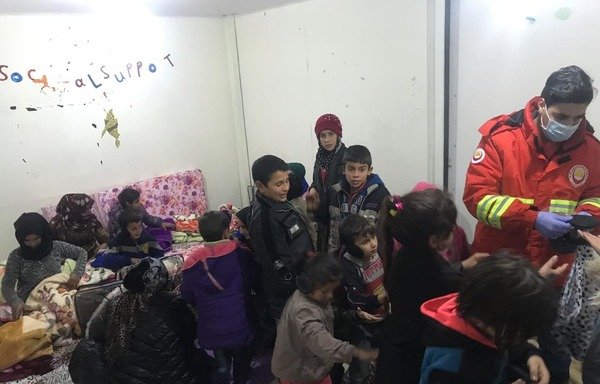 کارگران سازمان بسمه و زیتونه درمیان خانواده های پناهنده سوی در یکی از مراکز این سازمان در لبنان کمک توزیع می کنند. [عکس با کسب اجازه از سازمان بسمه و زیتونه]