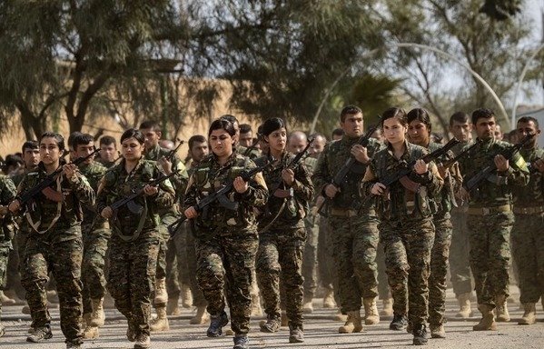 جنگجویان نیروهای دموکراتیک سوریه در یک راهپیمایی برای جشن در نزدیک میدان نفتی عمردر استان شرقی دیرالزور درروز 23 مارس شرکت می کنند پس ازآن که نابودی کامل آخرین استحکامات داعش در الباغوز اعلام شد.[دلیل سلیمان/خبرگزاری فرانسه]