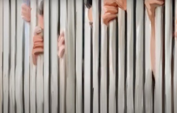 A screenshot from a video presentation of the Report of the Commission of Inquiry of Syria: 'Violation in Detention Facilities in Syria' shows an illustration of detainees in a Syrian prison.