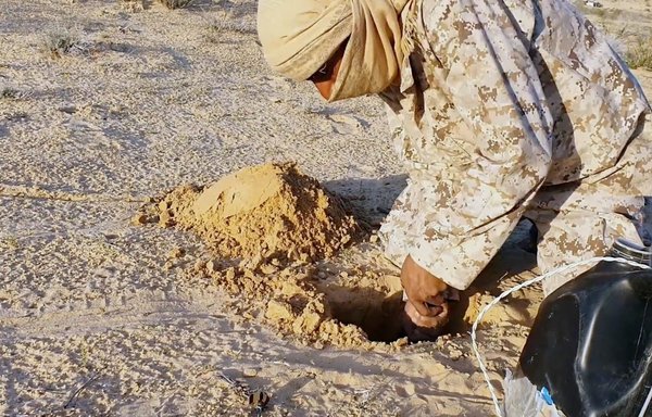 An ISIS militant is seen planting an improvised explosive device in Sinai, in this screenshot from a video posted on Telegram April 17.