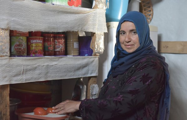 In her modest kitchen, Syrian refugee Awfa Ali al-Khodr prepares Ramadan iftar, which this year has been dominated by grains and vegetables. [Ziad Hatem/Al-Mashareq]