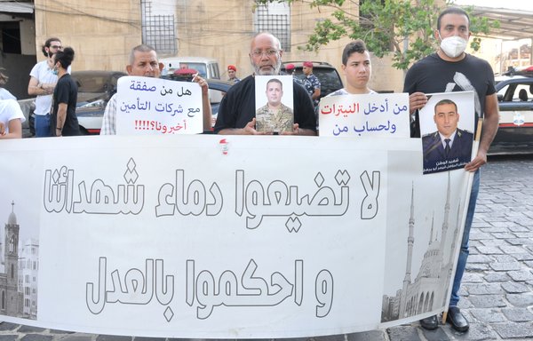 Families of the Beirut port explosion victims take part in a vigil in front of the port's main entrance on July 4. [Ziad Hatem]