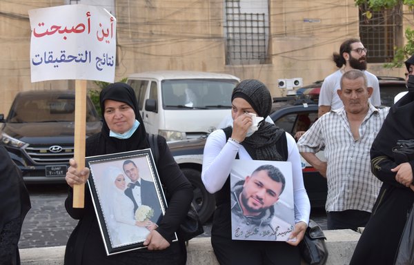 Women hold photos of sons and family members lost in the Beirut port explosion during a July 4 vigil. [Ziad Hatem]