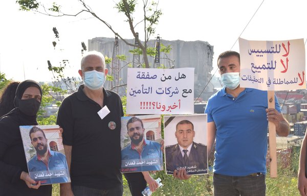 Family members of the victims of the Beirut port blast hold photos of their loved ones during a July 4 vigil. [Ziad Hatem]