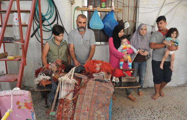 Abdel Wahab Shami works in the carpet repair and restoration business, a trade he learned from his father in Aleppo, to support his wife and five children. [Ziad Hatem]