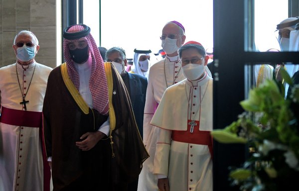 وصول الكاردينال لويس أنطونيو تاغلي (إلى اليمين) والشيخ عبدالله بن حمد آل خليفة (في الوسط) إلى كاتدرائية سيدة العرب قبيل افتتاحها في العوالي جنوبي المنامة في 9 كانون الأول/ديسمبر. وتعد الكنسية أكبر كاتدرائية للروم الكاثوليك في شبه جزيرة العرب. [مازن مهدي/وكالة الصحافة الفرنسية]