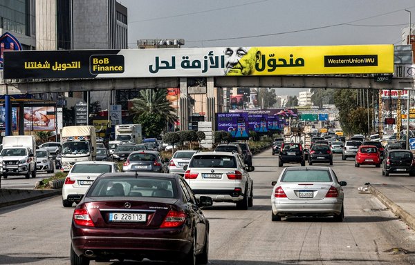 یک بیلبورد در بزرگراهی در بیروت در روز ۱۷ آذر یک مؤسسه انتقال پول را تبلیغ می کند. بیلبوردهای امسال به جای بیلبوردهای معمولی تبلیغاتی شامپاین و جواهرات قبل از کریسمس، راوی داستانی متفاوت و محقرتر هستند: این شرح حال بدترین بحران مالی در تاریخ این کشور است، کشوری که زمانی از ولخرج ترین کشورهای خاورمیانه بود. [جوزف عید/ خبرگزاری فرانسه]