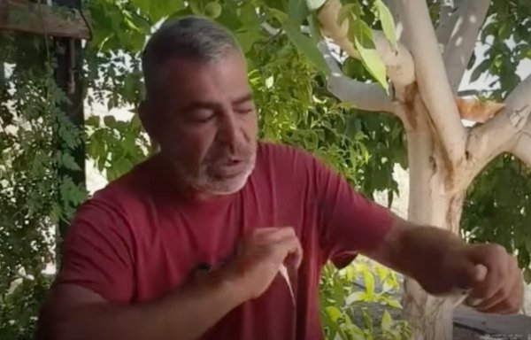 In a screenshot from a video posted on YouTube, disabled former Hizbullah fighter Hassan Mahmoud Mohsen tears up a picture of himself with Hizbullah chief Hassan Nasrallah.
